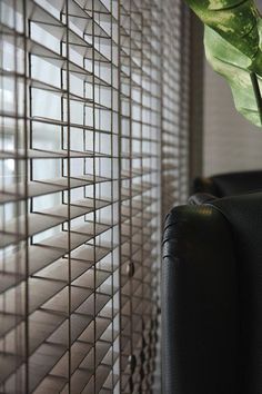 a green plant sitting on top of a chair next to a window covered in blinds