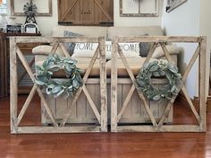 two pieces of wood with wreaths on them in front of a couch and coffee table