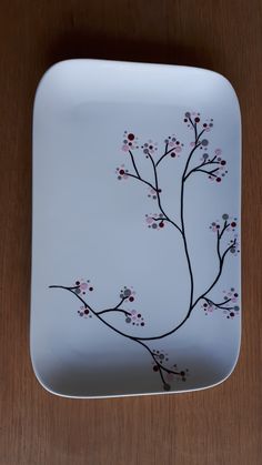 a white plate with a branch painted on it