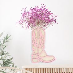 a pink vase with flowers in it sitting on a shelf next to a planter