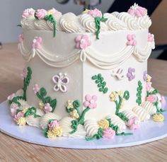 a white cake decorated with flowers and butterflies