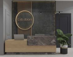 an office lobby with a marble reception desk and large sign on the wall that says lab doors