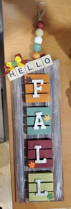 the letters are made out of wood and have autumn leaves on them as well as acrylic paint