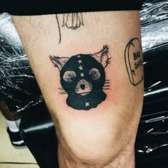 a cat tattoo on the leg of a man's leg, with an eyeball and stars