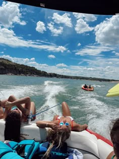 some people on a boat in the water and one is laying down with her feet up