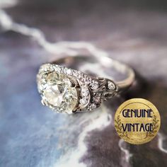 an antique diamond ring sits on top of a piece of paper with the word genuine vintage written below it