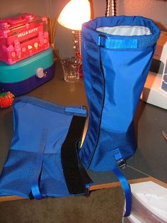 a blue bag sitting on top of a table next to a lamp and other items