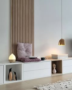 a living room with white furniture and wooden slats on the wall, along with a rug