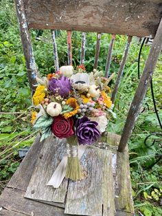 a bouquet of flowers sitting on top of a wooden chair