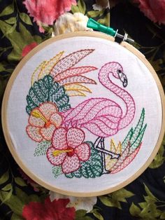 a flamingo with flowers and leaves on it's back is shown in the hoop