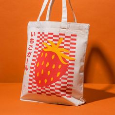 a bag with a strawberry on it sitting on an orange surface, against a brown background