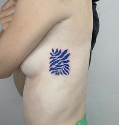 a woman's breast with a blue flower tattoo on it