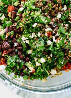 a glass bowl filled with lots of different types of vegetables and food on top of it