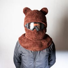 a person wearing a knitted bear hat and goggles