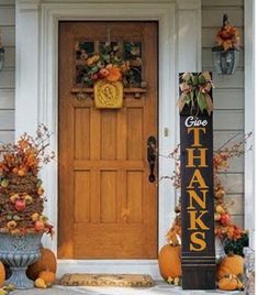 a front door decorated for thanksgiving with pumpkins and gourds