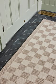 a checkered rug on the floor next to a door