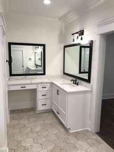 a white bathroom with two sinks and mirrors