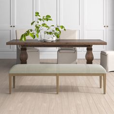 a dining room table with two chairs and a bench in front of it on a hard wood floor