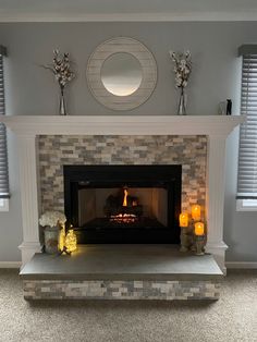 a living room with a fire place in the center and two candles on either side