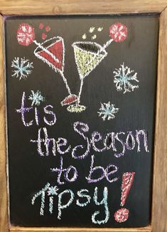 a chalkboard sign that says it's the season to be merry with two martinis