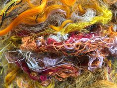 many different colored yarns are piled together