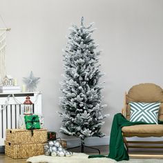 a white christmas tree in a living room next to a rocking chair and other holiday decorations