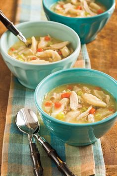 two bowls of chicken noodle soup on a table