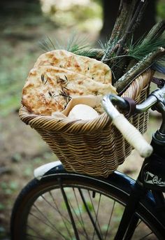 a basket filled with food sitting on the back of a bike