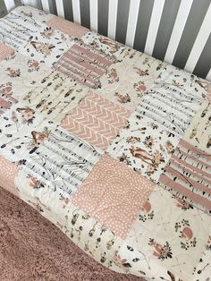 a baby crib with a pink and white quilt on it