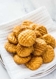 a plate full of peanut butter cookies on top of a white cloth with a fork