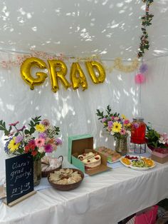 a table topped with lots of food next to a sign that says grad on it