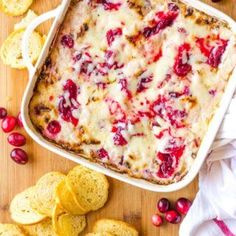 a casserole dish with cranberry sauce and crackers on the side