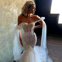 a woman in a wedding dress standing next to a wall