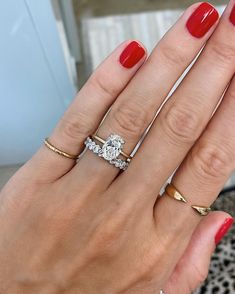 a woman's hand with three different rings on her fingers and one ring in the middle