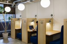 a person sitting at a desk with a laptop in front of them and some lights on the wall