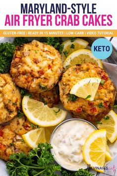 an image of crab cakes with lemons and parsley on the side for garnish