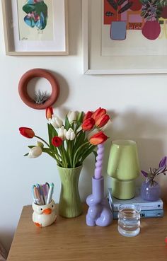 there is a vase with tulips and other flowers in it on the table