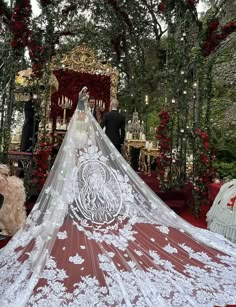 the bride is sitting in front of her wedding dress on the red and white carpet