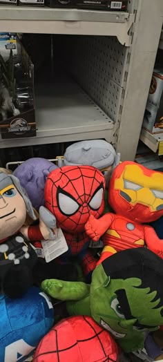 several stuffed toys are on display in a toy store, including spider - man and hulk - man