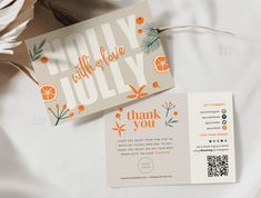 an orange and white folded thank you card next to a q - fold brochure