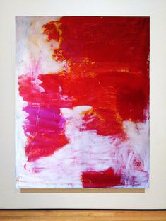 an abstract painting with red, white and yellow colors in a wooden frame on the wall