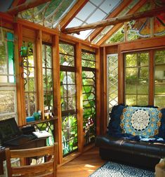 a living room filled with furniture and windows covered in stained glass panels on the walls