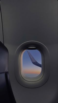 an airplane window showing the wing and sky