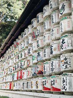 stacks of japanese tea cans stacked on top of each other in front of a building