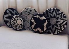 four black and white baskets sitting on top of a bed in front of a window