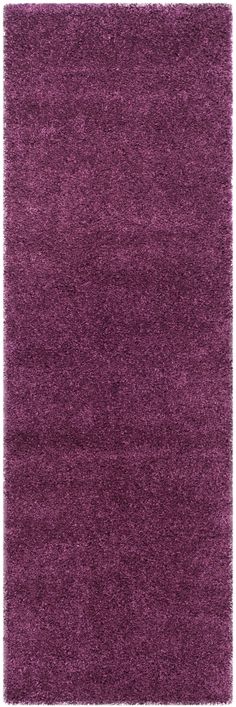 a purple rug with shaggy edges on the top and bottom, in front of a white background