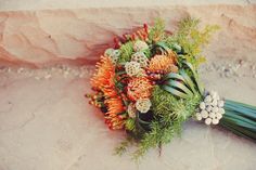 a bridal bouquet with orange and green flowers