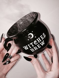 two hands holding a witches brew mug