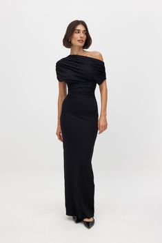 This maxi dress features a relaxed fit and a soft stretchy material. It has a draping design and a funnel collar. Our maxi dress has a side slit. Opera Gloves Dress, Maxi Dress Elegant Classy, Draped Black Dress, Collared Maxi Dress, Long Elegant Dresses With Sleeves, Formal Evening Outfits For Women, Long Black Elegant Dress, Chic Black Maxi Dress, Wedding Winter Outfit Guest