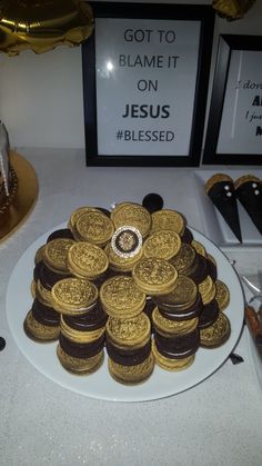 a white plate topped with cookies covered in gold oreos next to a sign that says, got to blame it on jesus